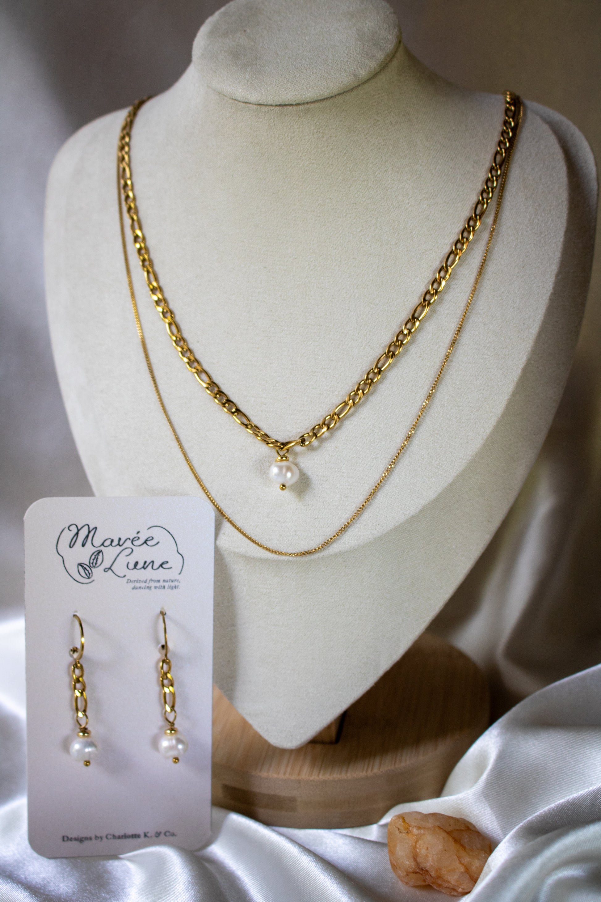 Elegant The Drop Necklace showcasing 18K gold PVD-plated chains and a stunning freshwater pearl, perfect for layering.